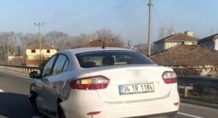 Parçalanmış lastikleri ve yerdeki tampon ile yoluna devam etti