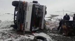 Karlı yolda kayan kamyonet yan yattı