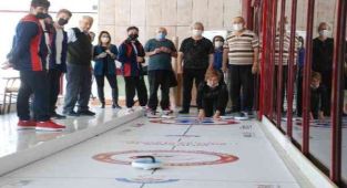 Yaşlılar ve gençlerin renkli curling müsabakası